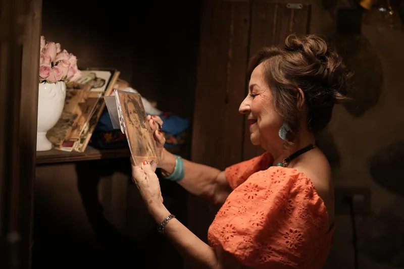 Mujer revisando fotografías en un set con iluminación cálida
